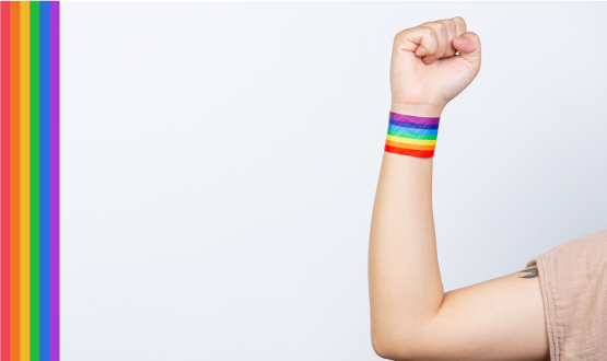 mujer alzando el puño con pulsera orgullo gay